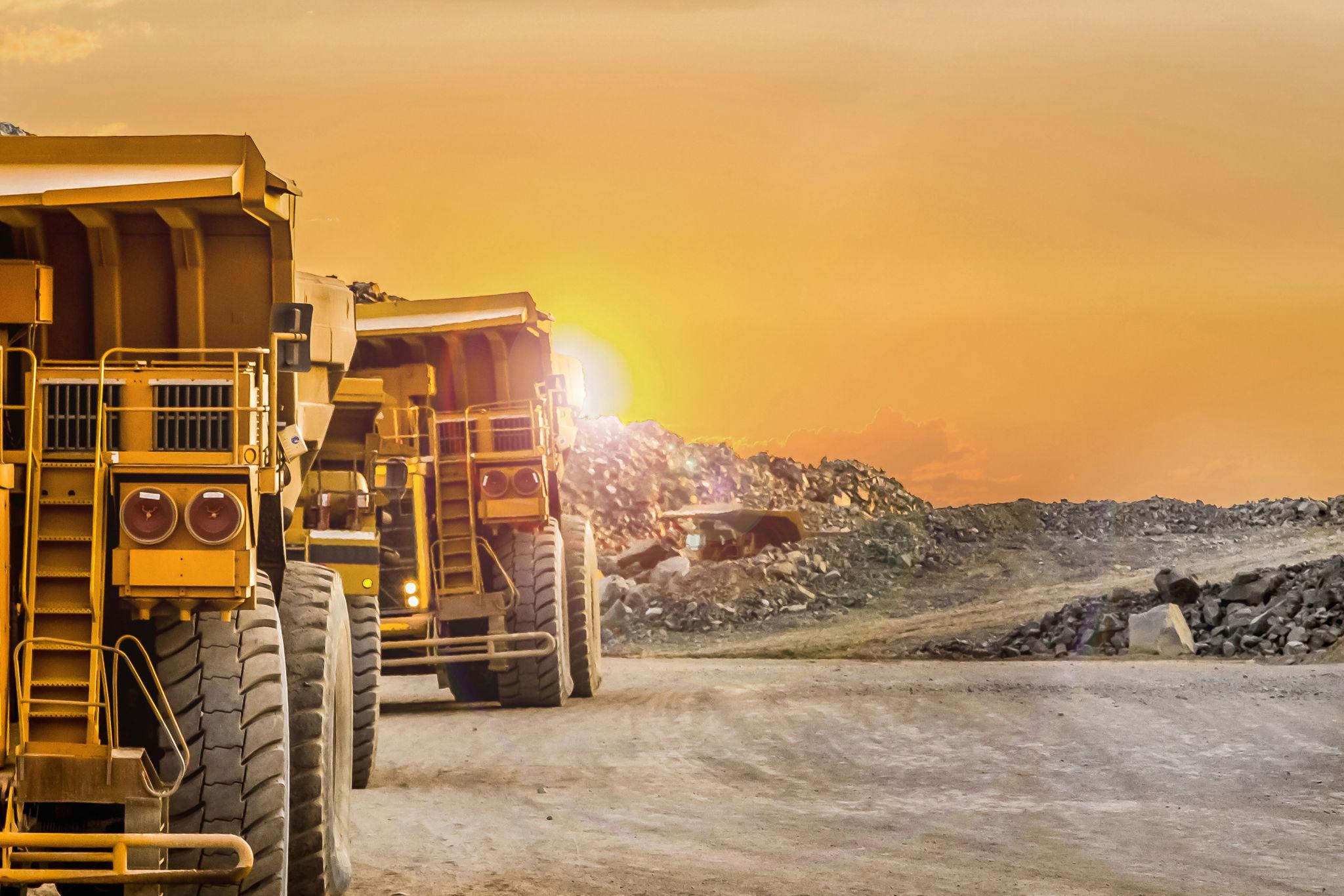 Mining trucks at sunset
